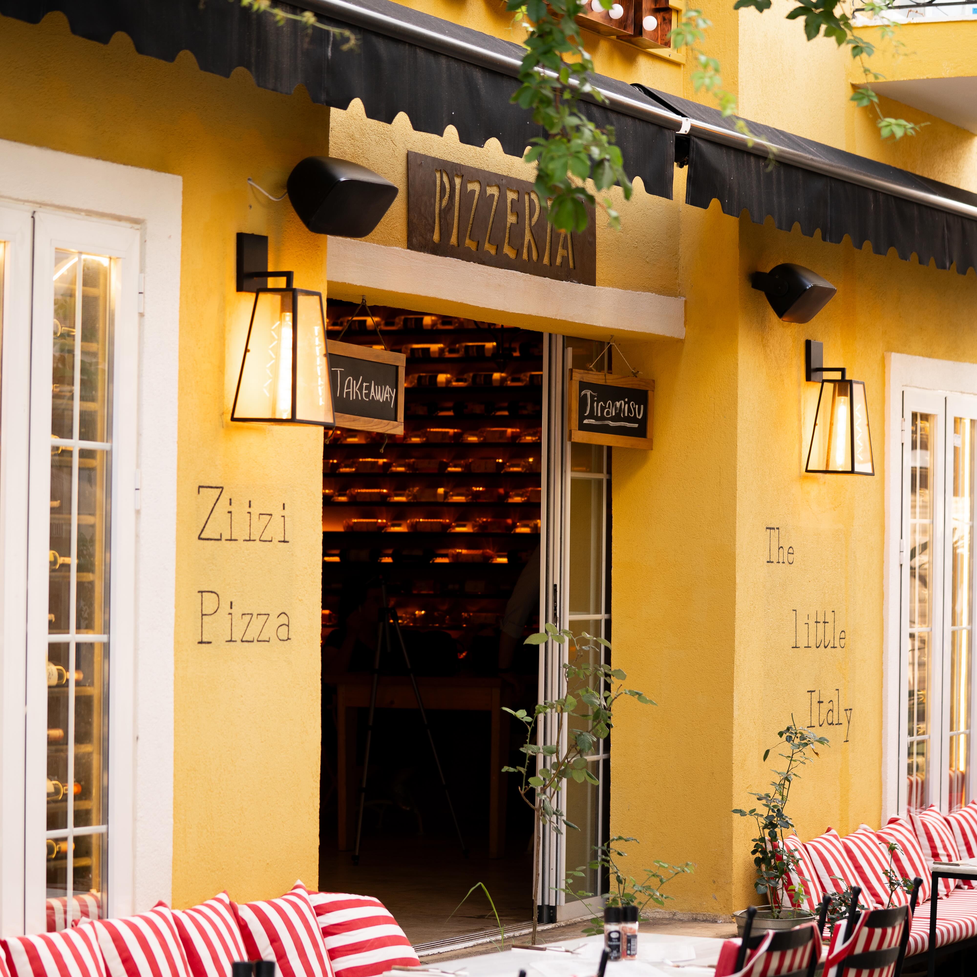 Ziizi Pizza — sarı cepheli pizzacımız ve çizgili minderleri